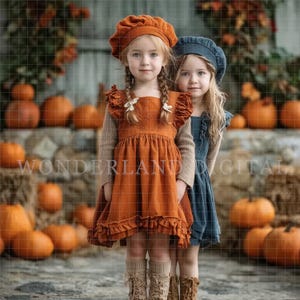 May include: Two young girls in autumn outfits pose in front of pumpkins. One wears an orange dress and beret, the other a blue dress and beret. The background features pumpkins and hay bales, evoking a harvest theme.
