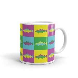 May include: White ceramic mug with a repeating pattern of colorful fish on a yellow, green, and purple background.