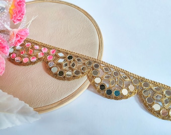May include: Gold trim with scalloped edges and round and diamond-shaped mirrored embellishments.