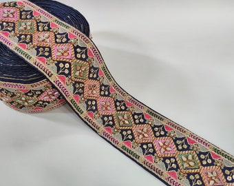 May include: A navy blue trim with gold, pink, green, and silver embroidery. The trim features a geometric pattern with mirrored accents.