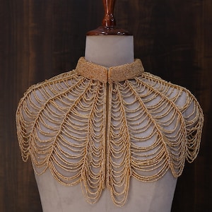 May include: A set of three ceramic mugs with a speckled, cream-colored glaze. Each mug features a different hand-painted design: a blue and green leaf, a yellow flower, and a red berry. The mugs have a simple, rounded shape and a comfortable handle.