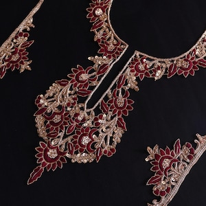 Può includere: Bordatura ricamata in bordeaux e oro con motivi floreali. Il bordo è perfetto per aggiungere un tocco di eleganza a qualsiasi capo.