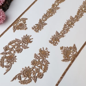 Op de afbeelding: Gouden florale borduurband met pailletten. De band is verkrijgbaar in verschillende lengtes en breedtes. Deze band is perfect om een ​​toets van elegantie toe te voegen aan elk project.