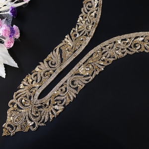 Puede incluir: Adorno de cuello de lentejuelas doradas con diseño floral. El adorno es perfecto para añadir un toque de elegancia a cualquier prenda.