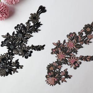 May include: Two floral appliques, one in black and one in pink, with intricate beading and floral designs.