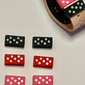 May include: Six watch band loops in three colors: black, red, and pink. Each loop has a white polka dot pattern.