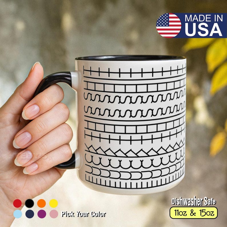 May include: White ceramic mug with a black handle and rim, featuring a repeating black geometric pattern. The mug is labeled "Made in USA" and "dishwasher safe", available in 11oz and 15oz sizes. The text "Pick Your Color" is also visible.