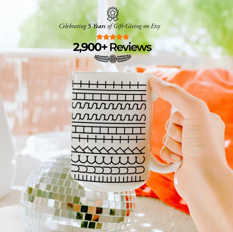 May include: White ceramic mug with a black geometric pattern and a white handle. The mug has the text "Celebrating 5 Years of Gift-Giving on Etsy" and "2,900+ Reviews". A hand is holding the mug.