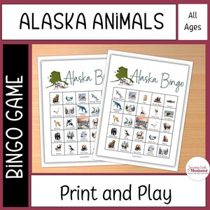 Op de afbeelding: Twee afgedrukte Alaska Bingo-spelbladen met illustraties van dieren uit Alaska. De titel "Alaska Animals" staat bovenaan, met "All Ages" ernaast. De zin "Print and Play" staat onderaan.