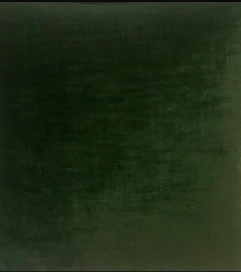 May include: A solid green velvet fabric swatch. The fabric has a subtle texture and a rich, deep green color.