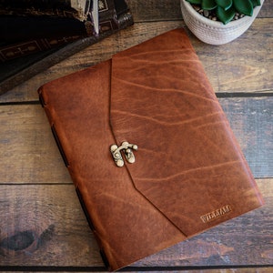 May include: A brown leather journal with a metal clasp and the name "William" embossed on the front.