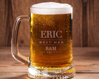 May include: A clear glass beer stein with a handle, filled with beer and a white foam head. The stein is engraved with the text "Eric Best Man R&M 03 May 2019."