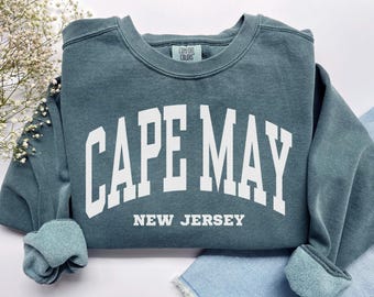 May include: A teal blue sweatshirt with white text that reads "CAPE MAY NEW JERSEY".