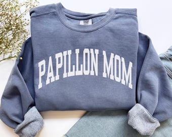 May include: A blue sweatshirt with white text that reads "Papillon Mom".