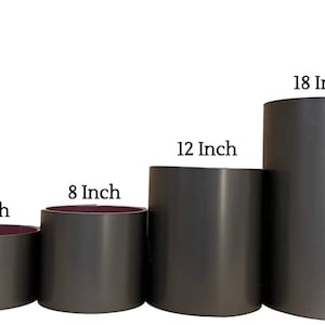 May include: Six gray metal cylinders of varying sizes, from 4 inches to 24 inches in diameter. The cylinders are arranged in a row from smallest to largest.