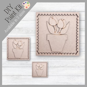 Puede incluir: Kit de pintura DIY con diseños de tulipanes de madera en tres tamaños. Cada pieza tiene un borde festoneado y un diseño de tulipán en una maceta. El texto "DIY Paint Kit" y "Available in 3 sizes" es visible.