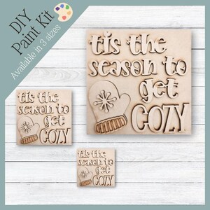 Könnte beinhalten: DIY-Mal-Set mit dem Text "Tis the season to get cozy" und einem Fäustlings-Design, erhältlich in drei Größen. Die Holzstücke sind unbemalt und bereit zum Bemalen.