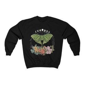 May include: Black sweatshirt with a green luna moth graphic, surrounded by flowers and a crescent moon design.