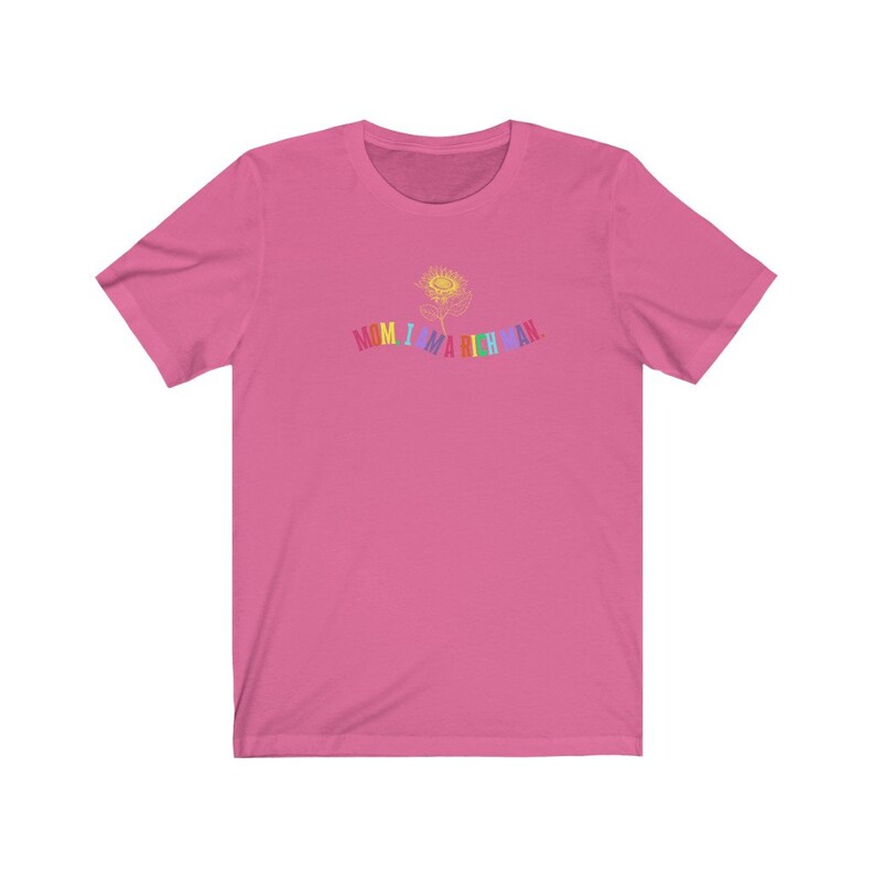 May include: Pink short-sleeved t-shirt with a rainbow graphic that says "MOM I AM A RICH MAN."