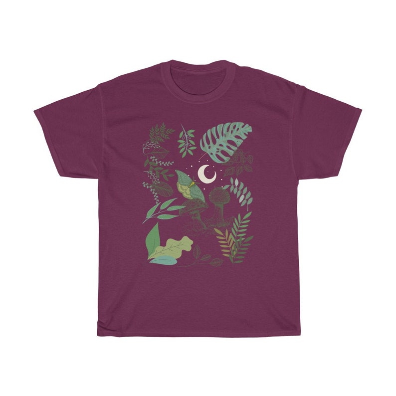 May include: A maroon t-shirt with a graphic design of a crescent moon and various green leaves and branches.