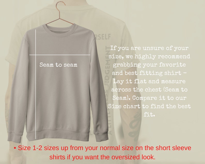 May include: A light gray sweatshirt with long sleeves and a crew neck. The text "Seam to seam" is written on the front of the sweatshirt. The text "If you are unsure of your size, we highly recommend grabbing your favorite and best fitting shirt - Lay it flat and measure across the chest (Seam to Seam). Compare it to our Size chart to find the best fit." is written on the right side of the sweatshirt. The text "Size 1-2 sizes up from your normal size on the short sleeve shirts if you want the oversized look." is written at the bottom of the image.