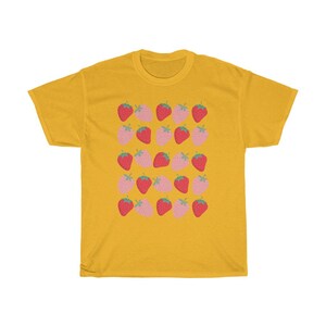 May include: A yellow t-shirt with a pattern of pink and red strawberries. The strawberries are arranged in rows and are all facing the same direction.