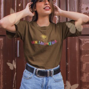 May include: A brown t-shirt with a rainbow sunflower graphic and the text "MOM, I AM A RICH MAN."