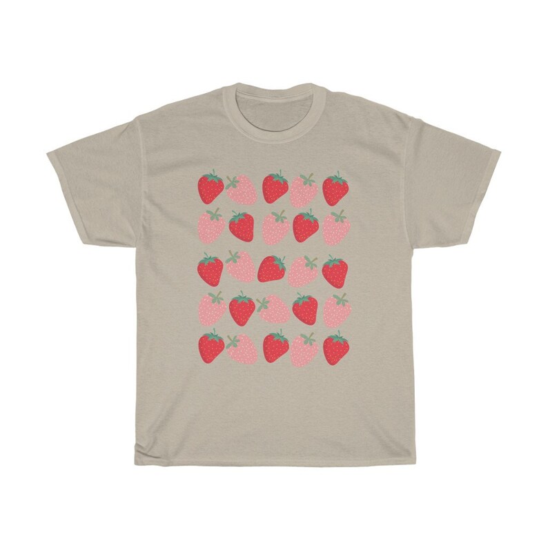 May include: A beige t-shirt with a repeating pattern of red and pink strawberries. The strawberries are stylized and have green leaves.