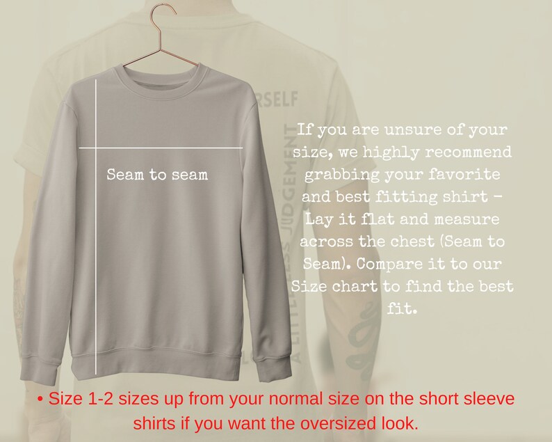 Op de afbeelding: Een lichtgrijs sweatshirt aan een hanger. De afbeelding bevat tekst met meetinstructies, waaronder "Seam to seam". Extra tekst adviseert om een maat groter te nemen voor een oversized look.