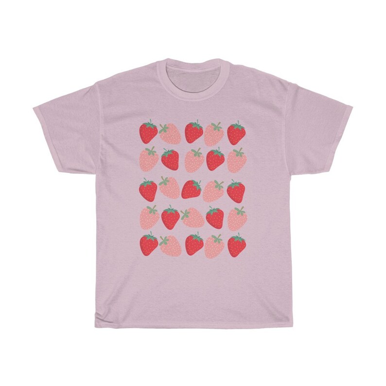May include: A light pink t-shirt with a repeating pattern of red and pink strawberries.
