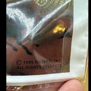 May include: A white ceramic mug with a black handle and the text "But First, Coffee" in a bold, black font. The mug is set against a blurred background, suggesting a cozy setting. The mug appears to be approximately 4 inches tall.