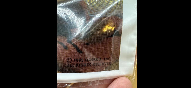 May include: A white ceramic mug with a black handle and the text "But First, Coffee" in a bold, black font. The mug is set against a blurred background, suggesting a cozy setting. The mug appears to be approximately 4 inches tall.