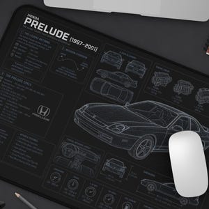 May include: A black rectangular desk mat featuring a white technical line drawing of a Honda Prelude 1997-2001. The design includes detailed engine schematics, interior dashboard layouts, and technical specifications printed in white text.