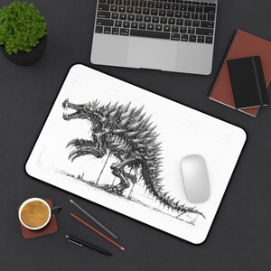 May include: A rectangular desk mat featuring a detailed black and white sketch of a spiky, dinosaur-like creature with a skeletal appearance. The illustration shows the creature in a side profile, standing on its hind legs with sharp claws.