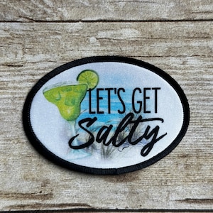 May include: A white and black round patch with a margarita glass and the text "Let's Get Salty".