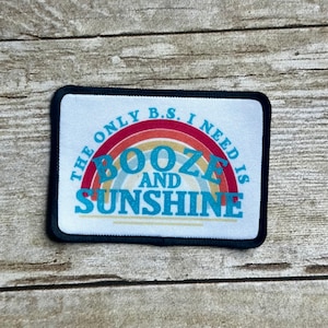 May include: White patch with black border featuring a rainbow with the text "The only B.S. I need is Booze and Sunshine" in blue and red.