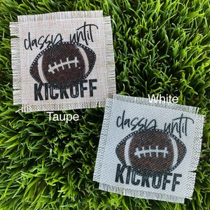 May include: Two square burlap coasters, one taupe and one white, with a football graphic. The text on each coaster reads "classy until KICKOFF" in black. The football is brown and white.
