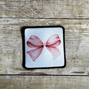 Pink bow patch with black border