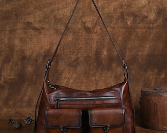 May include: A brown leather shoulder bag with two front pockets and a zippered pocket. The bag has a long adjustable strap.