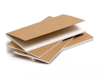 Puede incluir: Una pila de pequeños cuadernos de papel kraft marrón con páginas blancas rayadas. Los cuadernos están abiertos, revelando las páginas interiores, y están dispuestos en un patrón ligeramente superpuesto sobre un fondo blanco.