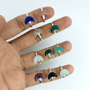 Peut inclure: Un ensemble de dix bagues en argent avec des pierres précieuses en forme de croissant de lune. Les pierres précieuses sont de différentes couleurs, notamment le bleu, le vert, le blanc et le rose.