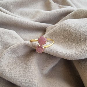 以下が含まれることがあります： 黒い持ち手と「But First, Coffee」の文字が黒い手書き風フォントで書かれた白いセラミックマグ。マグカップは白い表面に置かれています。