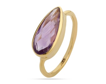 May include: A gold ring with a teardrop-shaped amethyst gemstone.