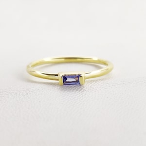 Peut inclure: Une bague en or avec une petite pierre précieuse rectangulaire violette.