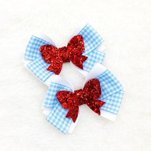 May include: Two red glitter bows with blue and white gingham ribbon.