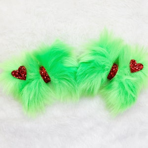 Peut inclure: Trois nœuds de cheveux en fourrure verte avec des accents de cœur rouge pailletés.