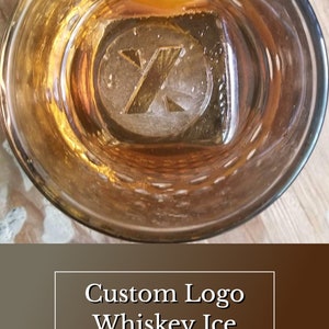 May include: A close-up of a whiskey glass with a custom logo ice cube and an orange peel garnish. The ice cube has a letter "X" design. The text "Custom Logo Whiskey Ice" and "SPeakeasy Ice Molds" is displayed below the image.
