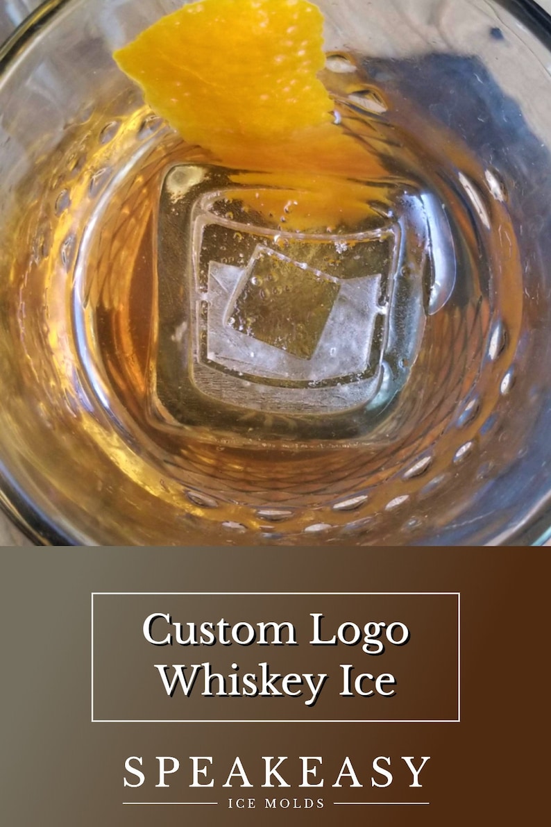 May include: A glass of whisky with an ice cube shaped like a logo. The ice cube has a square shape with a logo inside. The glass is on a brown surface. The text on the image reads "Custom Logo Whiskey Ice" and "Speakeasy Ice Molds".