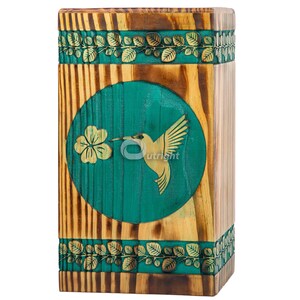 Può includere: Scatola di legno con un design circolare verde che presenta un colibrì e un fiore. La scatola è decorata con un motivo di foglie marroni e dorate.