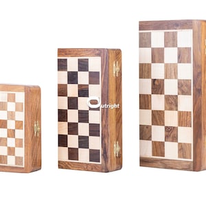 May include: Three wooden chessboards of different sizes, each with a hinged lid and brass clasps. The boards are made of light and dark wood, creating a classic checkerboard pattern.